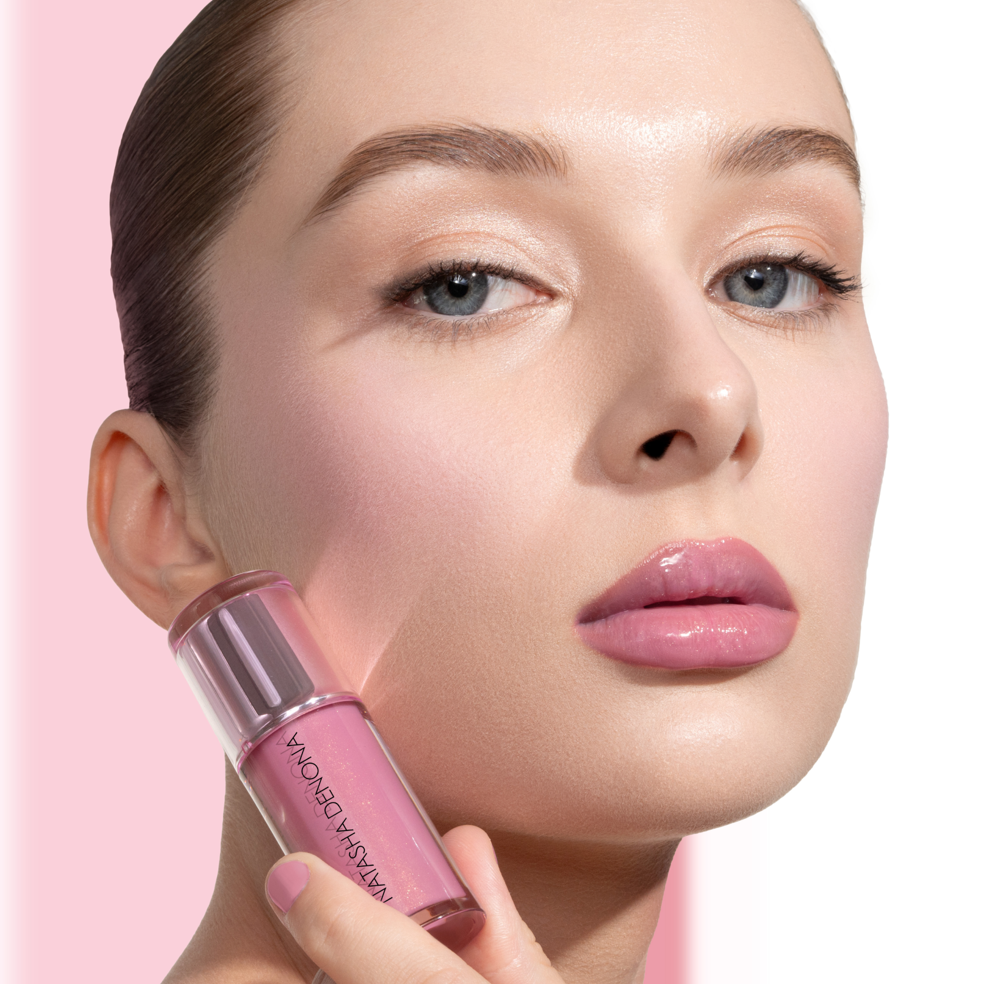 HY-GLOSS in shade 'Lush Lila' model look on a light-pink and white background. The model is holding the product in her hand.